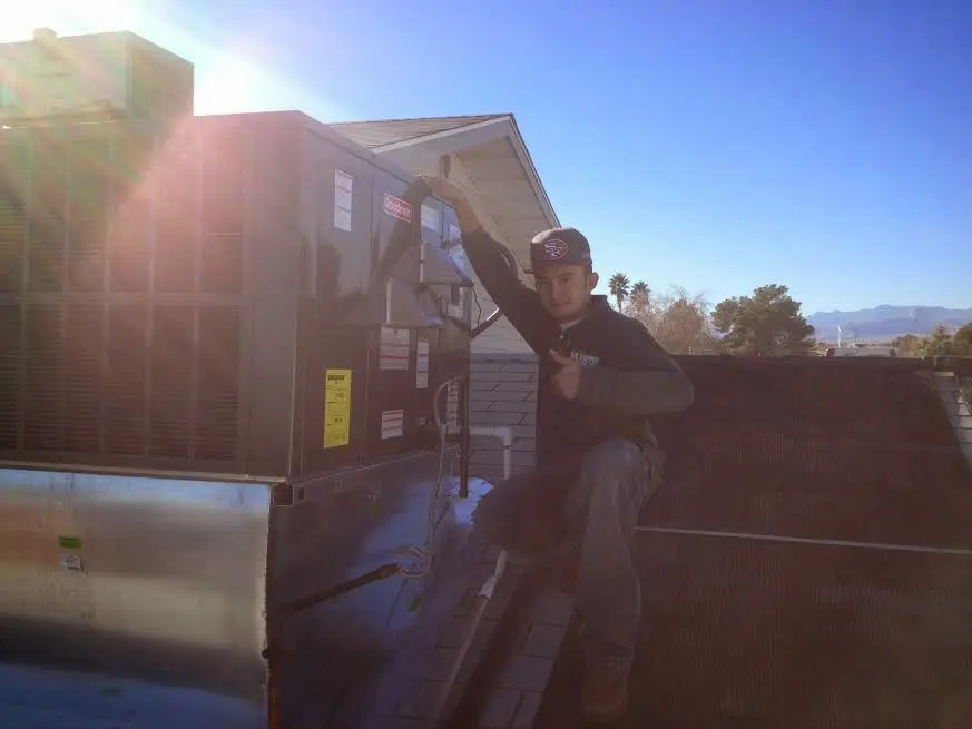 HVAC technician performing Air Duct Cleaning on a rooftop unit in Abbeville